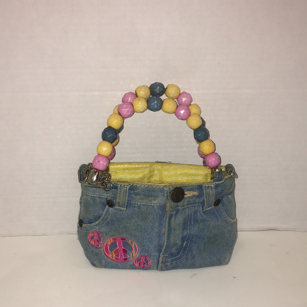 Preowned denim purse with beaded handles and peace patches.